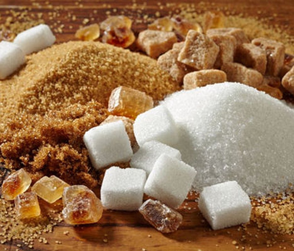 Piles of refined white and brown sugar cubes and crystals